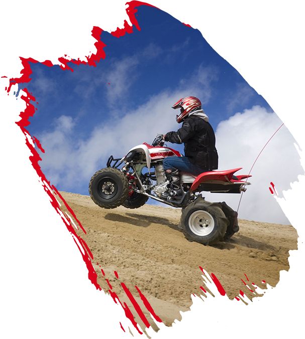 Riding quad bike on the Oregon Dunes against a deep blue sky